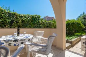 a table and chairs on a patio with a bottle of wine at Apartments Sun in Zadar