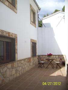 un patio esterno a una casa bianca con tavolo di Apartamentos La Iruela 2 a La Iruela