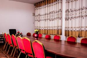 a conference room with a long table and red chairs at Mbale Travellers Inn in Mbale