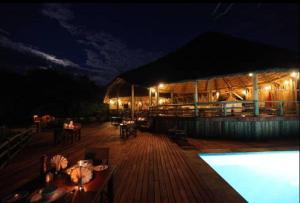 un edificio con piscina por la noche en Mbali Mbali Tarangire River Camp en Kwa Kuchinia