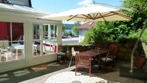 a wooden table with an umbrella on a patio at Ferienwohnung Bodensee in Überlingen