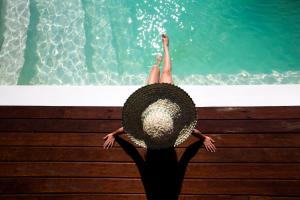 une personne assise sur un banc dans une piscine dans l'établissement Sentidos Beach Retreat, à Miramar