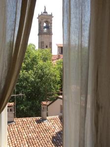 a view of a clock tower from a window at La Torta Di Mele in Bergamo
