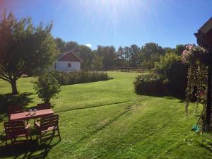 a park bench in a field with a barn in the background at Gånarps rum och Stuguthyrning in Ängelholm