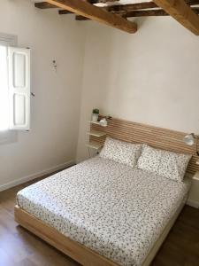 a bedroom with a bed with a wooden headboard at Le casette di Elen in Marsala