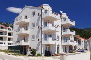 a white apartment building with balconies on a street at Vespera Apartments in Bol