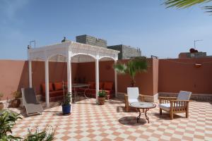 eine Terrasse mit einem Pavillon, einem Tisch und Stühlen in der Unterkunft Dar Chebba in Oualidia