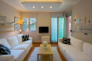 a living room with a white couch and a tv at Apia Residence in Budva