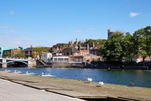 a group of swans on a river with a bridge at Sir Christopher Wren Hotel in Windsor
