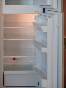 an empty refrigerator with its door open and a red object in it at Seaview Luxury Penthouse with Shared Swimming Pool in Għajnsielem