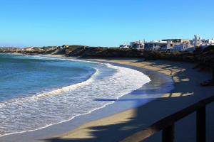 a beach with white buildings and the ocean at Seehuis Bismark in Langebaan