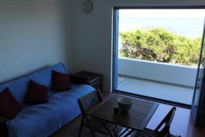 a living room with a blue couch and a table at Seehuis Bismark in Langebaan