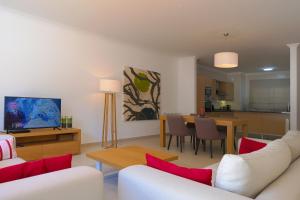 uma sala de estar com mobiliário branco e uma sala de jantar em Confortavel T2 em Óbidos