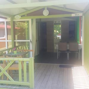 una veranda riparata con tavolo e sedie di Camping Covadonga a Soto de Cangas