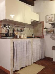 una cucina con bancone e armadietti bianchi di Tufoletto a Pitigliano