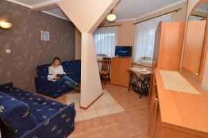 a woman sitting in a chair in a room at Willalux in Mielno