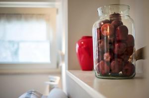 a glass jar filled with nuts and an apple on a counter at Riviera Carducci Rooms in Peschiera del Garda