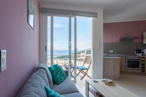 een woonkamer met een bank en uitzicht op de oceaan bij Seaview Luxury Penthouse in Għajnsielem