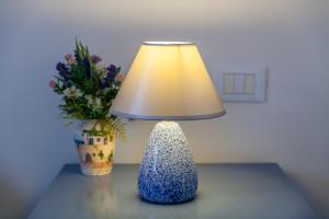 una lampada seduta su un tavolo accanto a un vaso di Villa Carenza a Monopoli