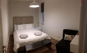 1 dormitorio con 1 cama con toallas en Shades of Grey - Lisbon, en Lisboa