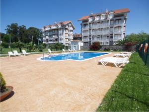 a swimming pool with lounge chairs and a building at Hotel Zenit Mar in Noja
