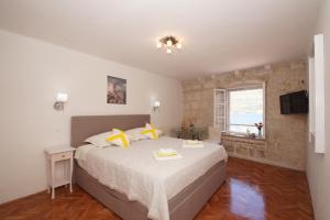 sypialnia z dużym łóżkiem i oknem w obiekcie Guest House Holiday w Korčuli