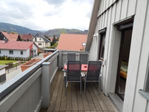 einen Balkon mit zwei Stühlen und einem Tisch darauf in der Unterkunft Gästehaus am Kirschberg in Ilsenburg