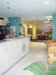 a restaurant with a bar and a person sitting at a counter at City Hotel in Geilenkirchen