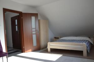 sypialnia z łóżkiem i drewnianymi drzwiami w obiekcie Dom wakacyjny Albert w mieście Mieroszyno