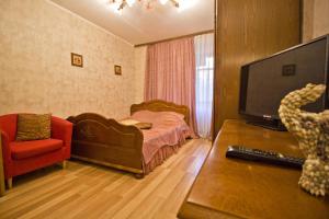 モスクワにあるLakshmi Great Apartment VDNHのベッドルーム(ベッド1台、テレビ、椅子付)