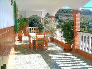 patio con mesa y sillas en el balcón en Holiday Home Eduardo, en Nerja
