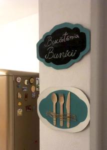 een bord op de zijkant van een koelkast met keukengerei bij Frăgăria in Zimandcuz