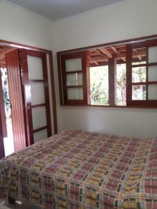 una camera da letto con un letto e due finestre di Sítio da Dinda - Campos do Jordão a Rosas