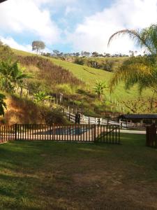 una recinzione davanti a un campo con una collina di Sítio da Dinda - Campos do Jordão a Rosas Altre 12 foto