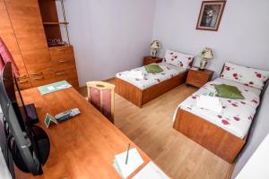 a small room with two beds and a table at The Rooms by Dalia in Košice
