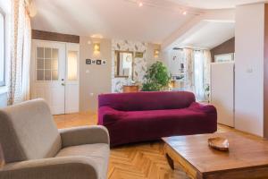 a living room with a red couch and a table at Apartments Sun in Zadar