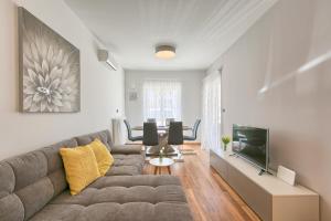 a living room with a couch and a tv at Adriatic Apartments Fažana in Fažana