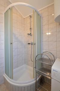 una doccia con porta in vetro in bagno di Apartmani Šime a Betina