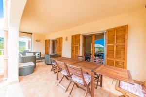 a dining room with a wooden table and chairs at Can Canals in Artá