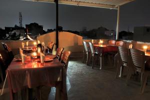 a set of tables and chairs on a balcony at night at Hotel Laxmi Palace in Udaipur
