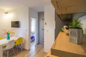 a kitchen and living room with a table and chairs at Apartments Sun in Zadar