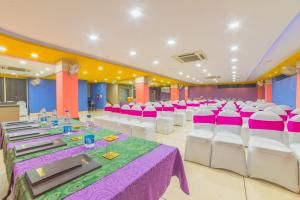 un salón de banquetes con mesas y sillas blancas y rosas en Hotel Heeralal, en Bikaner