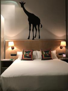 a bedroom with a bed with a giraffe on the wall at Chic & Basic Zoo in Barcelona