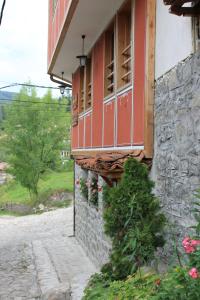 um edifício com uma janela vermelha do lado em Guest House Maria em Koprivshtitsa