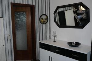 łazienka z umywalką i lustrem na ścianie w obiekcie Ferienwohnung Schmetterling w mieście Fritzlar