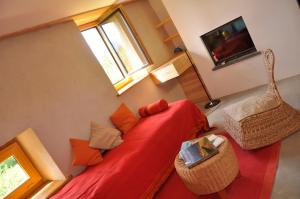 salon z czerwoną kanapą i telewizorem w obiekcie Ana'chronique w mieście Marat