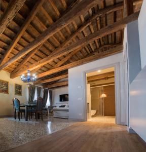 un soggiorno con soffitti in legno e una sala da pranzo. di San Marco Luxury apartments Muneghe a Venezia