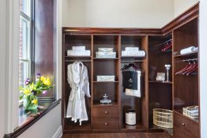 a wooden shelf with a robe in a room at Sydney Boutique Inn & Suites in Charlottetown +37 photos