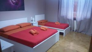 ナルドにあるMalvasia casa vacanzeのベッド2台 赤いシーツ&枕付