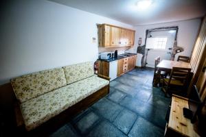 ein Wohnzimmer mit einem Sofa und einer Küche in der Unterkunft Casa Branca da Sociedade in Angra do Heroísmo